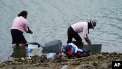 Locals wash clothes on the banks of the Villa Victoria reservoir in Mexico, Oct. 10, 2023.