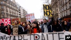 FILE: Protesters march during a demonstration in Paris, France, Wednesday, March 15, 2023. Opponents of French President Emmanuel Macron's pension plan are staging a new round of strikes and protests