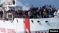 FILE - Migrants arrive by the Italian coastguard vessel Peluso in the Sicilian harbour of Augusta, Italy, May 13, 2016. 