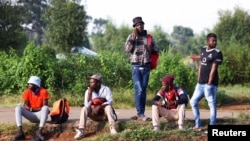 FILE - Job seekers wait beside a road for casual work offered by passing motorists in Eikenhof, south of Johannesburg, South Africa, March 3, 2022.