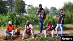 FILE: Job seekers wait beside a road for casual work offered by passing motorists in Eikenhof, south of Johannesburg, South Africa, on March 3, 2022. 