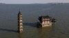 Foto udara dengan drone menunjukkan kuil dan pagoda yang sebagian terendam banjir di atas pulau Luoxingdun saat permukaan air di danau Poyang mendekati titik tertinggi menyusul hujan lebat di wilayah Lushan, provinsi Jiangxi, China. (Reuters)&nbsp;