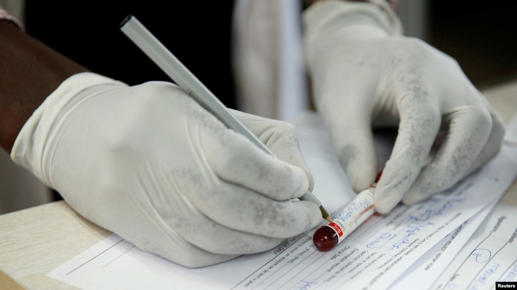 FILE - A doctor registers blood after testing a patient at a local government hospital in Harare, Zimbabwe, Feb. 4, 2020