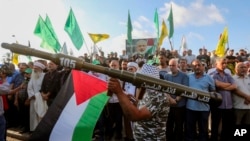 Seorang pendukung Hizbullah dan Hamas menunjukkan roket tiruan dalam demo untuk mengutuk pembunuhan kepala politik Hamas, Ismail Haniyeh, di Kota Sidon, Lebanon, Rabu, 31 Juli 2024. (Foto: Mohammed Zaatari/AP Photo)