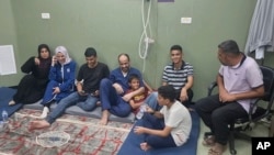 This video grab shows Mohammed Abu Selmia, center, the director of Gaza's main hospital, who was detained by Israeli forces, sitting with his family after his release, along with other detainees, at a hospital in Khan Younis, Gaza Strip, July 1, 2024.