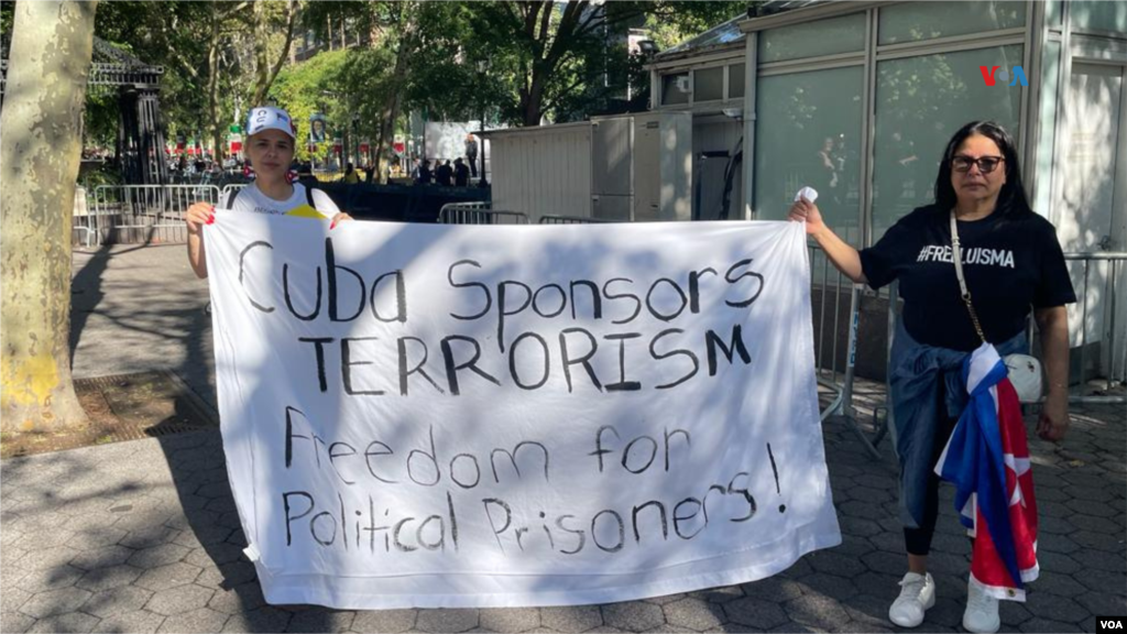 Exiliados cubanos sostienen un cartel donde se lee en inglés &quot;Cuba, patrocinadores del terrorismo. Libertad para los presos políticos&quot;, en una plaza en las afueras de la sede de la ONU en Nueva York, el 19 de septiembre de 2023.