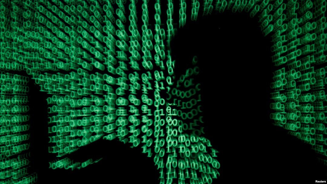 Un hombre sostiene una computadora portátil mientras se le proyecta un código cibernético en esta fotografía ilustrativa tomada el 13 de mayo de 2017.