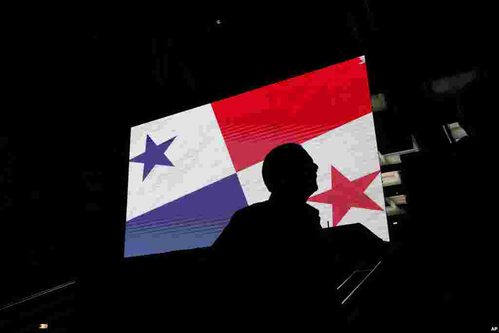 Seorang pendukung calon presiden Achieving Goals Jose Raul Mulino berdiri di dekat layar bendera Panama di luar markas kampanyenya saat menunggu hasil pemilu di Panama City, Minggu, 5 Mei 2024. (Foto: Matias Delacroix/AP Photo)