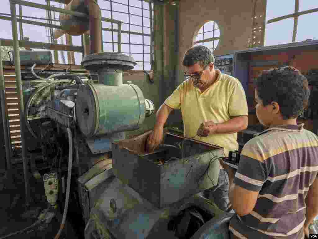 Gamal, a longtime electrician, fixes a core generator at a poultry farm. "If the metal can't endure, how can we?" he asks, referring to the machine that keeps overheating. Cairo, Egypt, May 23, 2024. (Hamada Elrasam/VOA)