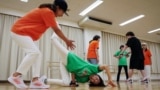 Mieko Nanba, 68, (center) practices a breakdance move known as 'chair freeze' during a training session with their team Ara Style Senior, Japan's only breakdancing club made up of elderly citizens, in Tokyo, Japan, May 20, 2024. (REUTERS/Kim Kyung-Hoon)