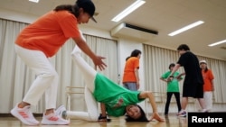 Mieko Nanba, 68, (center) practices a breakdance move known as 'chair freeze' during a training session with their team Ara Style Senior, Japan's only breakdancing club made up of elderly citizens, in Tokyo, Japan, May 20, 2024. (REUTERS/Kim Kyung-Hoon)