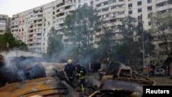 Пожарные работают на месте авиаудара в Харькове, Украина, 14 мая 2024 года