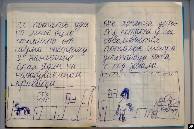 Two pages of the diary of Yehor Kravtsov, 10 years-old, are exhibited at the War Diaries exhibition, showcasing the personal diaries of Ukrainian children who have witnessed the war. (AP Photo/Peter Dejong)