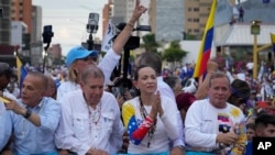 Presidential candidate Edmundo Gonzalez, second from left, and opposition leader Maria Corina Machado, second from right, attend a campaign rally in Maracaibo, Venezuela, July 23, 2024. The presidential election is set for July 28.