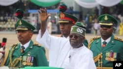 FILE - Nigeria's new President Bola Ahmed Tinubu inspects honor guards after taking an oath of office at a ceremony in Abuja, Nigeria, May 29, 2023.