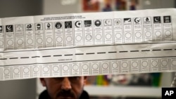 An election official holds a ballot with a vote for the Republican People's Party, or CHP, at a polling station in Istanbul, March 31, 2024. The CHP won municipalities of 36 of Turkey’s 81 provinces, making inroads into strongholds of President Recep Tayyip Erdogan’s party. 