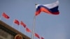 FILE - The Russian flag flutters at the Great Hall of the People in Beijing, May 24, 2023. The U.S. has added more Chinese companies to its Entity List for reportedly helping firms affiliated with the Russian military obtain U.S.-made goods that cannot legally be sold to them. 