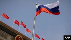 FILE - The Russian flag flutters at the Great Hall of the People in Beijing, May 24, 2023. The U.S. has added more Chinese companies to its Entity List for reportedly helping firms affiliated with the Russian military obtain U.S.-made goods that cannot legally be sold to them. 