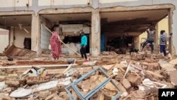 People inspect the rubble at a house that was hit by an artillery shell in the Azhari district in the south of Khartoum on June 6, 2023. 
