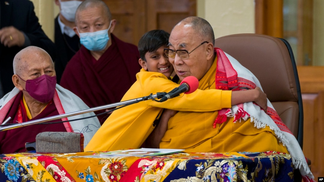 Seorang anak laki-laki memeluk pemimpin spiritual Tibet Dalai Lama dalam sebuah acara di mana pemimpin Tibet itu berbicara kepada sekelompok siswa di kuil Tsuglakhang di Dharamshala, India, Selasa, 28 Februari 2023. (Foto: AP)