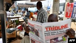 A vendor reads a paper at a newsstand at Ikeja district of Lagos, Feb. 27, 2023 while the country awaits results for the presidential elections. 
