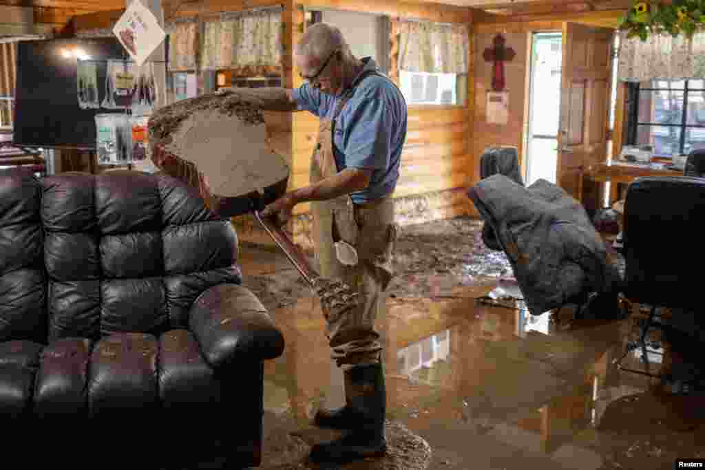 Bobby Smith, 70, the property manager of the River Ranch RV Park empties flood water out of their club house guitar after the property was damaged due to a flash flood in the aftermath of the Central New Mexico fires in Ruidoso Downs, New Mexico.