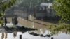 Residents stand near flood waters outside their homes following heavy rains in Pakistan's Khyber Pakhtunkhwa province, April 17, 2024. The province has now issued a flood alert due to glacial melting, officials said.