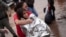 A firefighter carries a girl rescued from an area flooded by heavy rains in Porto Alegre, Rio Grande do Sul state, Brazil, May 4, 2024. 