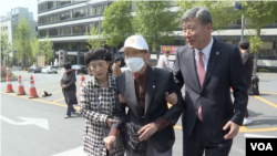 한국전쟁 당시 북한 공산군에 포로로 끌려갔다 51년 만에 탈북해 한국으로 돌아온 김성태 씨(가운데)가 지난 4월 북한 김정은 정권을 상대로 제기한 손해배상 재판에 참석하기 위해 법원에 입장하고 있다.