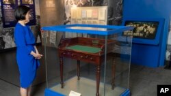 FILE - In this May 2023 photo, Luci Baines Johnson looks at the desk that her father, President Lyndon B. Johnson, sat at to sign the Voting Rights Act of 1965. The desk is on display at the LBJ Presidential Library in Austin, Texas.