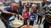 فلسطینی‌ها در حال دریافت غذاهای پخته شده سازمان خیریه «أشپزخانه مرکزی جهان» در غزه - آرشیو