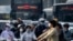 Para komuter tampak menggunakan masker ketika melewati distrik bisnis di Beijing, pada 26 Mei 2023. (Foto: AP/Mark Schiefelbein)