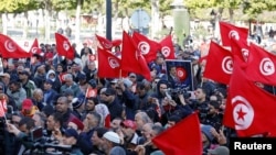 Supporters of Tunisia's Salvation Front opposition wave flags during a protest over the arrest of some of its leaders and other prominent critics of the president, in Tunis, March 5, 2023. 