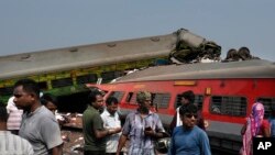 People inspect the site of passenger trains that derailed in Balasore district, in the eastern Indian state of Orissa, June 3, 2023.