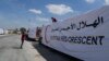 Pengemudi Mesir menutupi truk bantuan kemanusiaan mereka saat menunggu untuk melintasi perbatasan Rafah antara Mesir dan Jalur Gaza, 23 Maret 2024. (Foto: AP)