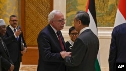 FILE - Chinese Foreign Minister Wang Yi, right, shakes hands with Palestine Foreign Minister Riyad al-Maliki as he meets with his five Arab and Islamic counterparts at the Diaoyutai state guesthouse in Beijing, Nov. 20, 2023. 