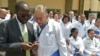 资料照片：肯尼亚基苏木省省长安扬·尼永戈教授（左）与参加位于内罗毕肯尼亚政府学院项目的100名古巴医生之一交谈。（2018年6月11日）