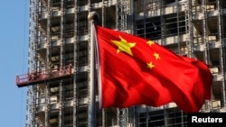 Bendera nasional China berkibar di lokasi pembangunan kompleks perumahan baru di Beijing pada 4 November 2013. (Foto: Reuters)