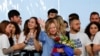 Italy's Prime Minister Giorgia Meloni gestures, as she holds a bouquet of flowers, during a "Brothers of Italy" (Fratelli d'Italia) right-wing party conference in Pescara, April 28, 2024. 