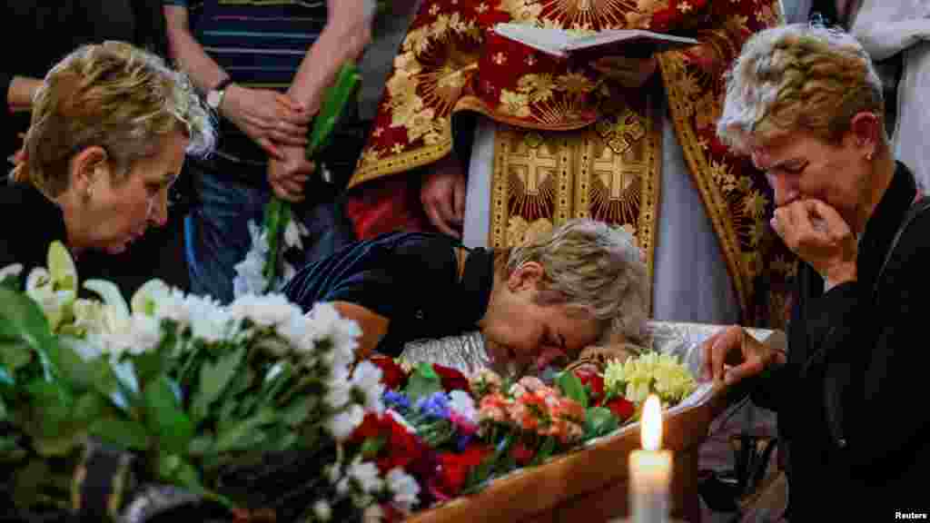 Relatives of a Ukrainian serviceman recently killed fighting Russian troops in Zaporizhzhia region, grieve during a funeral ceremony, amid Russia&#39;s attack on Ukraine, in the Church of St. Nicholas in Kyiv.