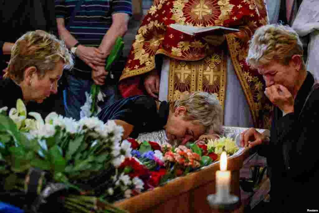 Kerabat seorang prajurit Ukraina baru-baru ini tewas melawan pasukan Rusia di wilayah Zaporizhzhia, berduka selama upacara pemakamannya, di tengah serangan Rusia terhadap Ukraina, di Gereja St. Nicholas di Kyiv.