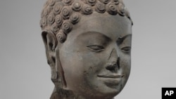 This December 2005 photo shows a 7th century sculpture titled "Head of Buddha" at the Metropolitan Museum of Art in New York. The sculpture is one of 16 pieces of artwork that the museum said it will return to Cambodia and Thailand. (Metropolitan Museum of Art via AP)