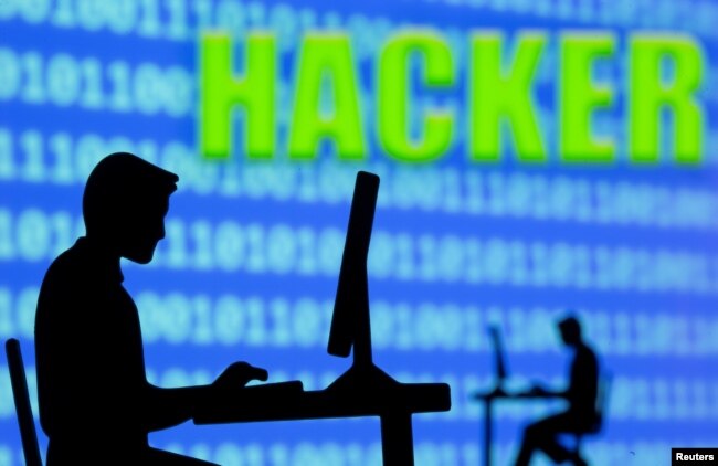 Seorang pria terlihat di depan tampilan kode biner dan tulisan "Hacker" dalam sebuah ilustrasi, 5 Juli 2021. (Foto: REUTERS/Dado Ruvic)