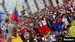Una persona sostiene una imagen del difunto expresidente venezolano Hugo Chávez durante un mitin del gobierno para conmemorar el Día de la Juventud, en Caracas, Venezuela, el 12 de febrero de 2023.