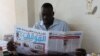 FILE - Mathiang Cirillo, editor in chief of Almaugif newspaper, reads his paper from his office in Juba March 6, 2023. (VOA/John Tanza)