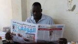 FILE - Mathiang Cirillo, editor in chief of Almaugif newspaper, reads his paper from his office in Juba March 6, 2023. (VOA/John Tanza)