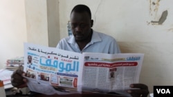 FILE - Mathiang Cirillo, editor in chief of Almaugif newspaper, reads his paper from his office in Juba March 6, 2023. (VOA/John Tanza)