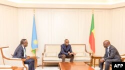 FILE - Rwandan President Paul Kagame (C) gestures towards Beninese Foreign Minister Aurelien Agbenonci (R) upon his arrival at Cotonou Cadjehoun Airport on April 15, 2023. 