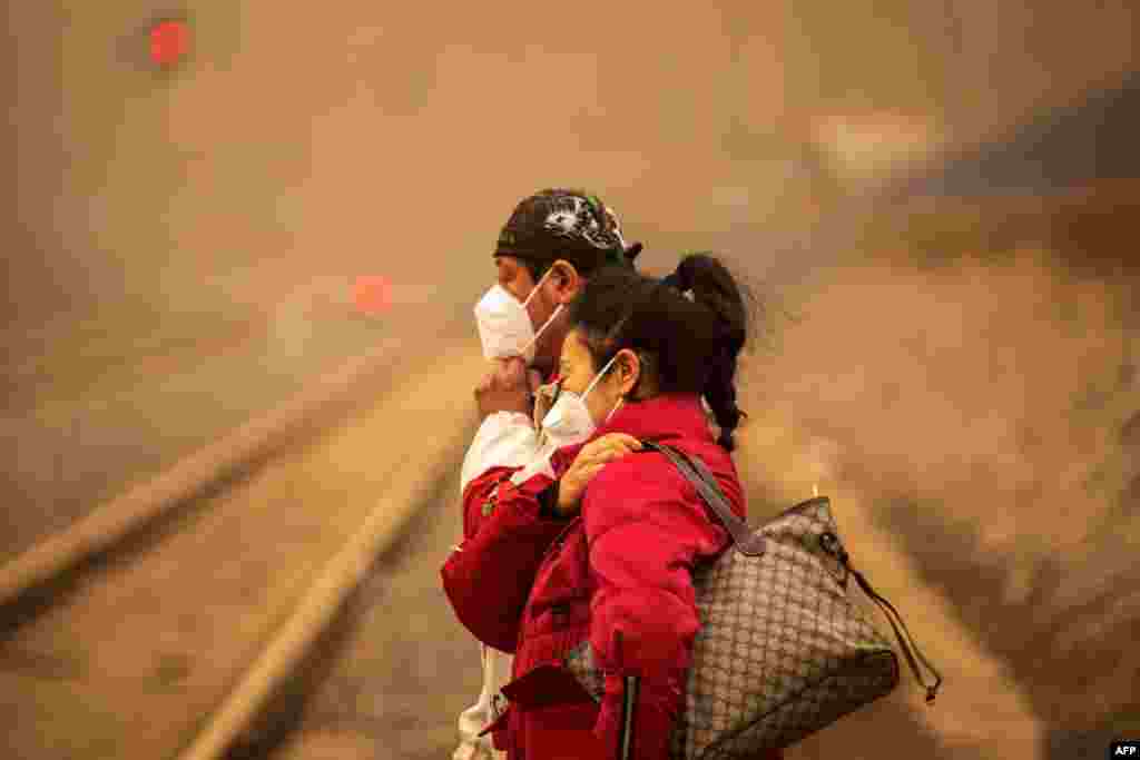 People wearing masks walk on a street during a sandstorm in Jilin, in northeastern China&#39;s Jilin province.