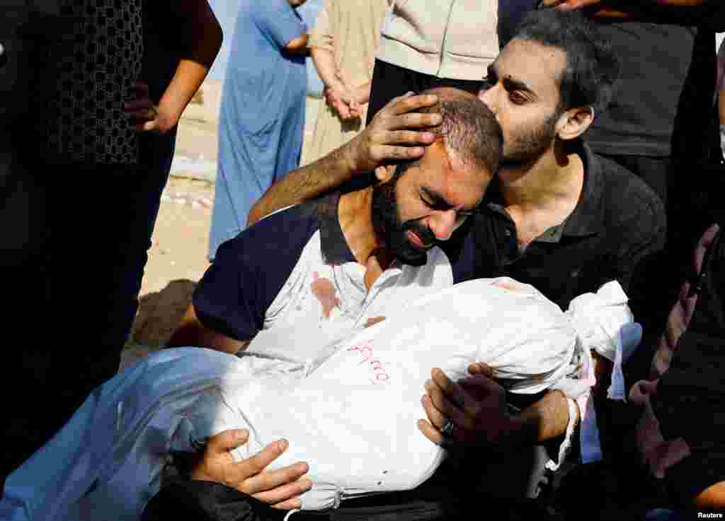 Таткото на Алма Ал Маџајда (3), убиена во израелски напади, го прегрнува нејзиното тело за време на нејзиниот погреб, среде тековниот конфликт меѓу Израел и палестинската исламистичка група Хамас, во Кан Јунис во јужниот дел на Појасот Газа.